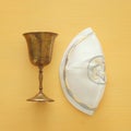 Top view image of jewish wine cup for wine next to Kippah yarmulke (hat). passover holiday and shabbat concept.