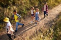 Top view image of kids, boys and girls walking on path in forest, field, going hiking together on warm summer day Royalty Free Stock Photo