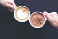 Top view image of man and woman`s hands holding coffee and hot chocolate cups