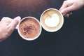 Man and woman`s hands holding coffee and hot chocolate cups with wooden table background Royalty Free Stock Photo