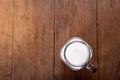 top view image milk in a jug and a glass on wooden table