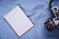 top view image of open notebook with blank pages and camera on blue blackground. Royalty Free Stock Photo