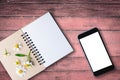 top view image of open notebook with blank pages next to chamomile flower, blank smart phone on old wooden table. ready for Royalty Free Stock Photo