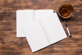 top view of open notebook with blank pages next to cup of coffee on wooden table. ready for adding text or mockup Royalty Free Stock Photo