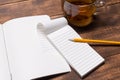 top view image of open notebook with blank pages next to cup of coffee on wooden table. mockup Royalty Free Stock Photo