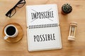 Top view image of open notebook with the text impossible, cutting the word im so it written possible. success and challenge concep Royalty Free Stock Photo