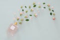 Top view image of perfume bottle with rose petals flowers over pastel blue background. Floral scent concept. Royalty Free Stock Photo