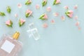 Top view image of perfume bottle with rose petals flowers over pastel blue background. Floral scent concept. Royalty Free Stock Photo