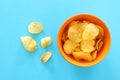 Top view image of potato chips slices in the bowl over pastel blue background Royalty Free Stock Photo