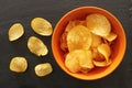 Top view image of potato chips slices in the bowl over slate stone background Royalty Free Stock Photo