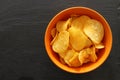 Top view image of potato chips slices in the bowl over slate stone background Royalty Free Stock Photo