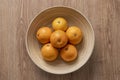 Top view image of round bamboo wood fruit bowl with Valencian oranges