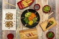 Top view image of sushi and japanese food set. Wakame salad, edamame pods with sea salt flakes, shrimp rolls, prawn Royalty Free Stock Photo