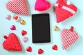 Top view image of tablet, colorful heart shape chocolates, fabric hearts on wooden background. valentine's day celebration concept