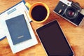 Top view image of tablet with empty screen, old camera passport and flight boarding pass