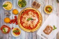 Top view image of typical Italian dishes with lots of basil, margarita pizza, tiramisu, bolognese noodles, cherry tomatoes,