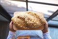 A waitress holding and serving a loaf of whole grain bread Royalty Free Stock Photo