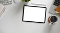 The top view image of white workspace is surrounding by a blank screen tablet and various equipment. Royalty Free Stock Photo