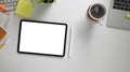 The top view image of white workspace is surrounding by a blank screen tablet and various equipment. Royalty Free Stock Photo