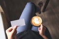 A woman holding an empty business card while drinking coffee cup Royalty Free Stock Photo