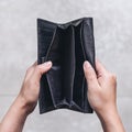 Woman`s hands open an empty black leather wallet with floor background Royalty Free Stock Photo