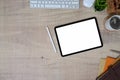 Top view image of a workspace is surrounding by a computer tablet with a white blank screen. Royalty Free Stock Photo