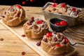 Top view of individual plum cakes, decorated with sugar, raisins and cherries, selective focus, on rustic table, Royalty Free Stock Photo