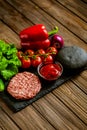 Top view of ingredients for beef black burger on a black stone board. Delicious food concept Royalty Free Stock Photo