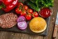 Top view of ingredients for classic beef burger on a black stone board with knife. Selective focus. Royalty Free Stock Photo