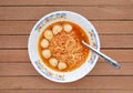 Top view instant noodles with meat balls in ceramic bowl against wooden plank