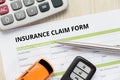 Top view of insurance claim form with car key, car toy and calculator on wooden desk Royalty Free Stock Photo