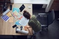 Top view of interior designer or architect in casual wear with messy hairdo working on a blueprint for new project Royalty Free Stock Photo