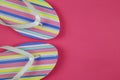 Top view on isolated colorful striped pair flip flops on pink background with copy space Royalty Free Stock Photo