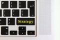 Top view isolated laptop keyboard with yellow `strategy` text on button, concept design f Royalty Free Stock Photo