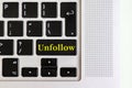 Top view isolated laptop keyboard with yellow `unfollow` text on button, concept design f Royalty Free Stock Photo