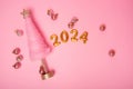 Top view Isolated pink background creative Christmas tree, golden numbers 2024 with balls. New Year