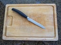 Top view of an Isolated serrated utility knife on a large wooden cutting