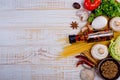 Top view on italian pasta, vegetable, olive oil in bottle, mushrooms, tomatos, egg, parsley, bad, nutmeg, chilli on white.