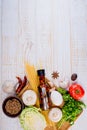 Top view on italian pasta, vegetable, olive oil in bottle, mushrooms, tomatos, egg, parsley, bad, nutmeg, chilli on white wooden.