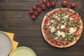 Top view of italian pizza, cherry tometoes and empty plates Royalty Free Stock Photo