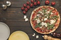 Top view of italian pizza, cherry tometoes and empty plates Royalty Free Stock Photo