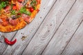 Top view of italian pizza on a rustic table background. A piece of salami pizza with red hot chili pepper. Copy space.