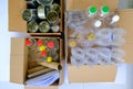 Top view of items to be recycled, paper glass plastic bottles containers metal aluminium cans, sorted into cardboard boxes. Zero Royalty Free Stock Photo