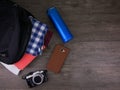 Top view Items for trip included clothes in black bag,blue water bottle,mobile phone and camera on wooden background Royalty Free Stock Photo