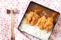 Top view Japanese curry rice topping with fried chicken and vegetables in black plate with chopsticks.