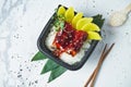 Top view on Japanese white rice with eel in teriyaki sauce and mango in lunchbox on white background. Copy space. Street food Royalty Free Stock Photo