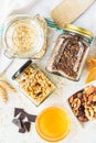 Top view of jars full of oats and various crunchy granola - plain, dried fruits, nuts and chocolate. Healthy eating concept Royalty Free Stock Photo