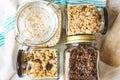 Top view of jars full of oats and various crunchy granola - plain, dried fruits, nuts and chocolate. Healty eating concept Royalty Free Stock Photo