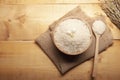 Top view of jasmine rice with jasmine flower on top in a wooden bowl,  spoon burlap sack and  ear of rice with wooden background Royalty Free Stock Photo