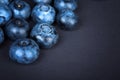 Top view of juicy blueberries on a dark background, top view. Fresh, raw and ripe blueberries full of vitamins. Summer fruits.